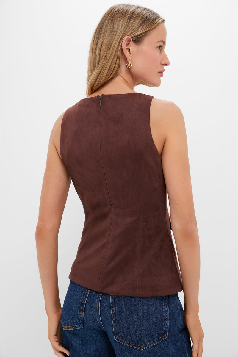 Woman in classic, mocha-brown Brown Faux Suede Franz Top with high neckline, back zip, and gold-accented faux pockets, paired effortlessly with medium-wash jeans.