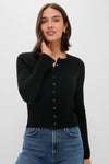 A woman wears a fitted, ribbed cotton-wool blend button-up cardigan from Alex Mill with blue jeans.