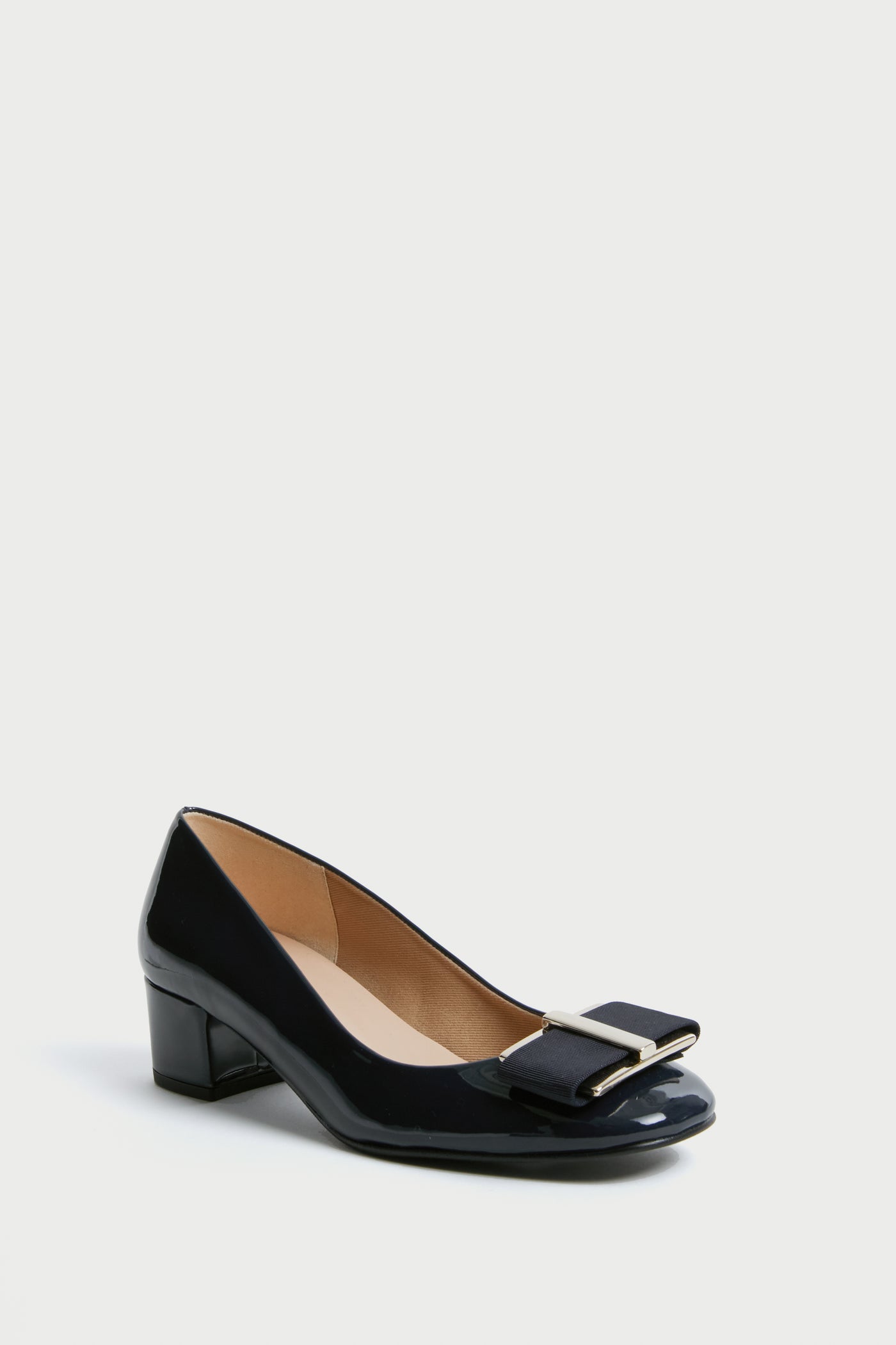 The French Sole black patent leather low-heeled shoe features a rounded toe, decorative bow, and metal accent on the front—ideal for block heel enthusiasts.