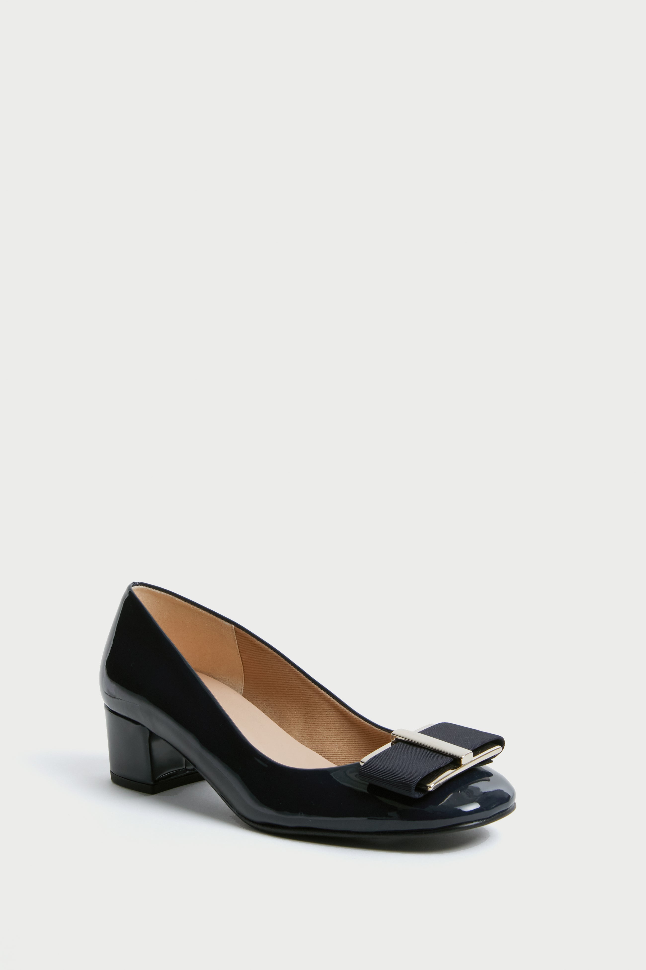 The French Sole black patent leather low-heeled shoe features a rounded toe, decorative bow, and metal accent on the front—ideal for block heel enthusiasts.
