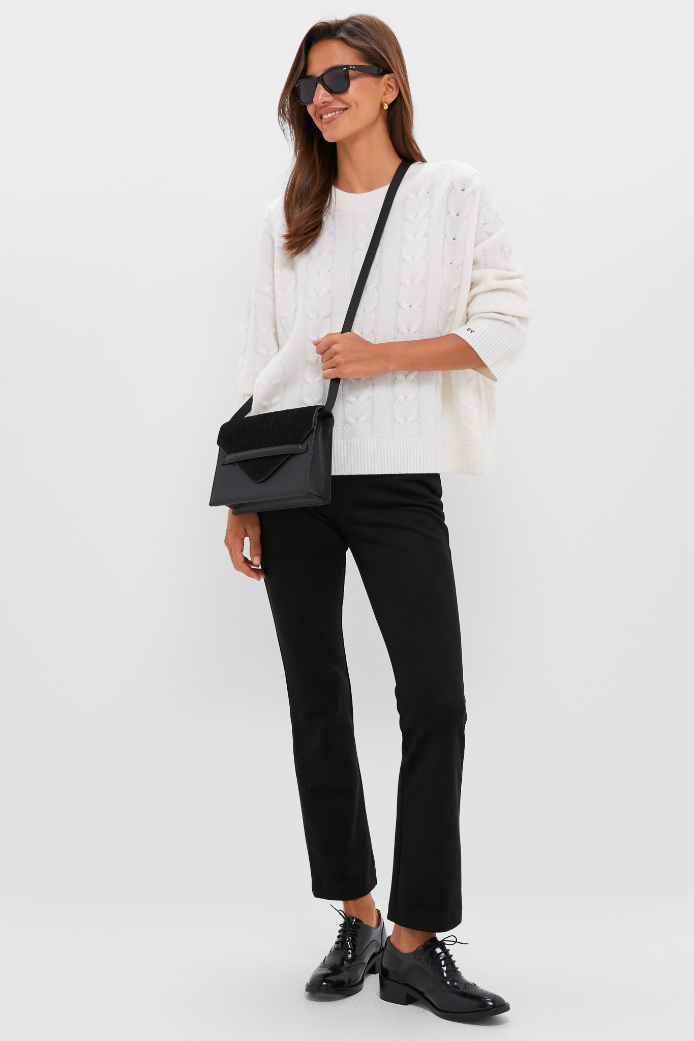 Woman wearing classic Black Leather Brogue Oxford Shoes with cut-out detailing and a block heel, styled with trousers, embodying an effortless, high-end, fun look.