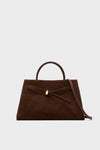 A Veronica Beard brown Italian suede bag with a top handle, gold clasp, and removable shoulder strap is shown against a plain, light background.