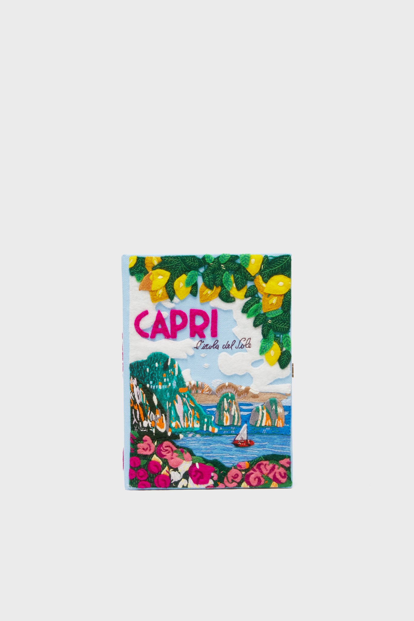 A towel by Olympia Le-Tan featuring a landscape and boat, inspired by the brand’s iconic book clutch designs.