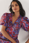 Woman in a red and blue floral patterned dress. 