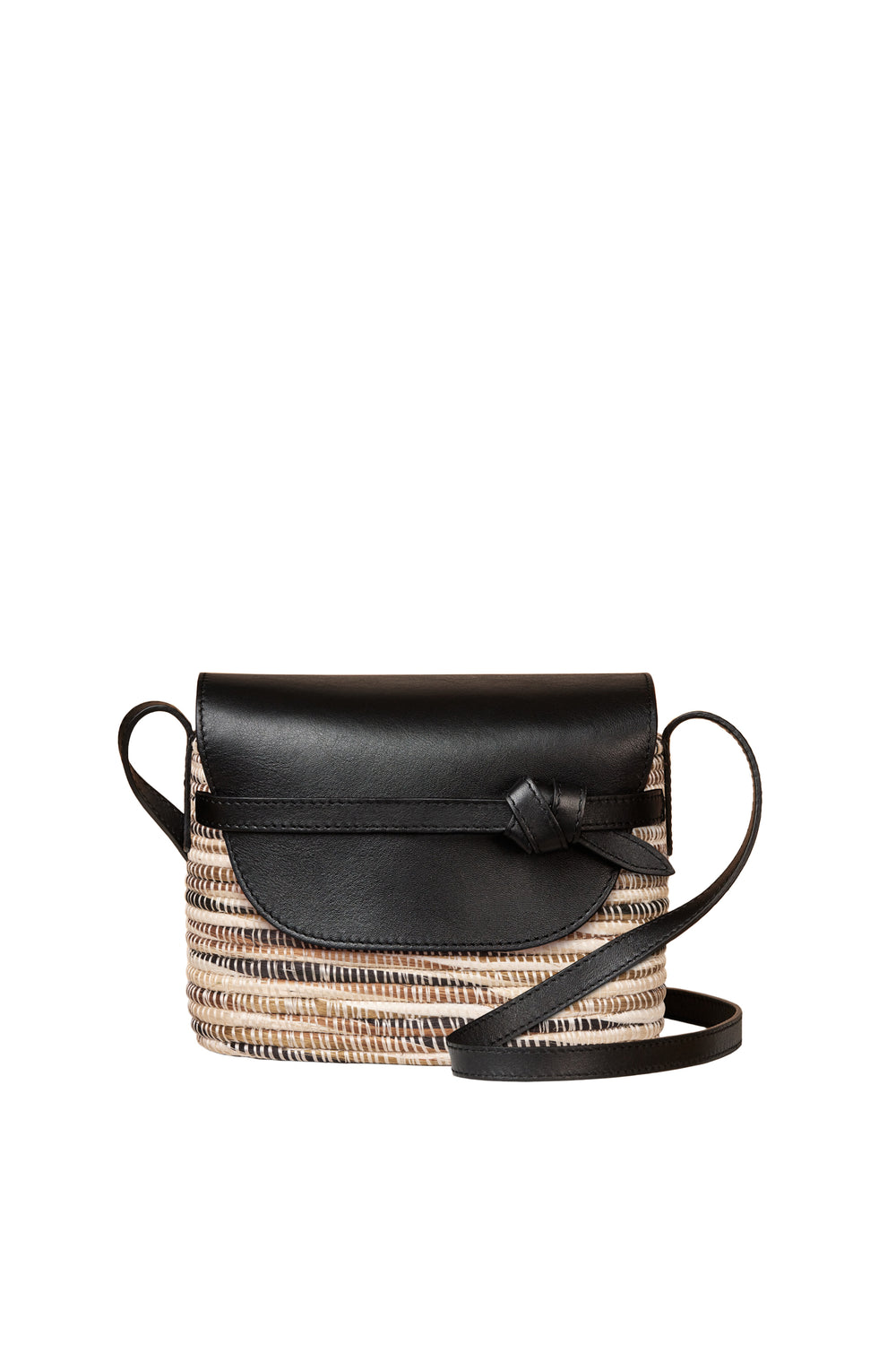 The Cesta Collective crossbody bag is inspired by handwoven baskets and features a woven base, black leather flap with knot detail, and a long leather strap.