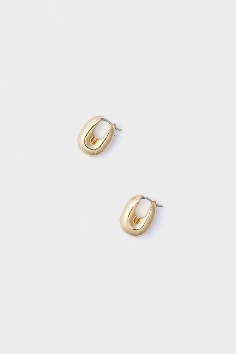 Pair of small, chunky gold-plated brass huggie hoops with a polished finish by Jenny Bird.