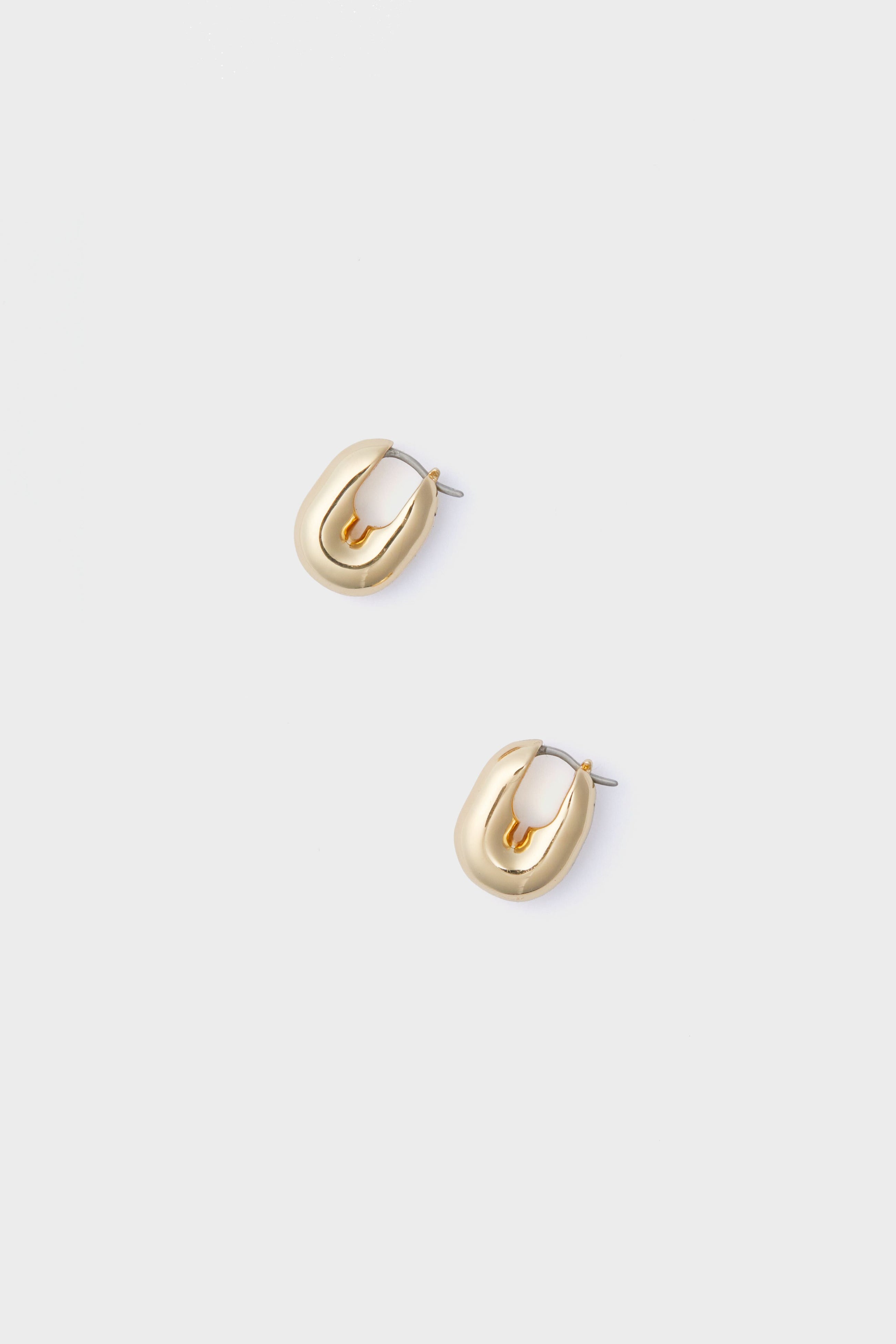 Pair of small, chunky gold-plated brass huggie hoops with a polished finish by Jenny Bird.