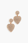 A pair of Jennifer Behr 24k gold-plated heart-shaped earrings features round tops adorned with small white pearls in a honeycomb pattern—ideal luxury accessories.