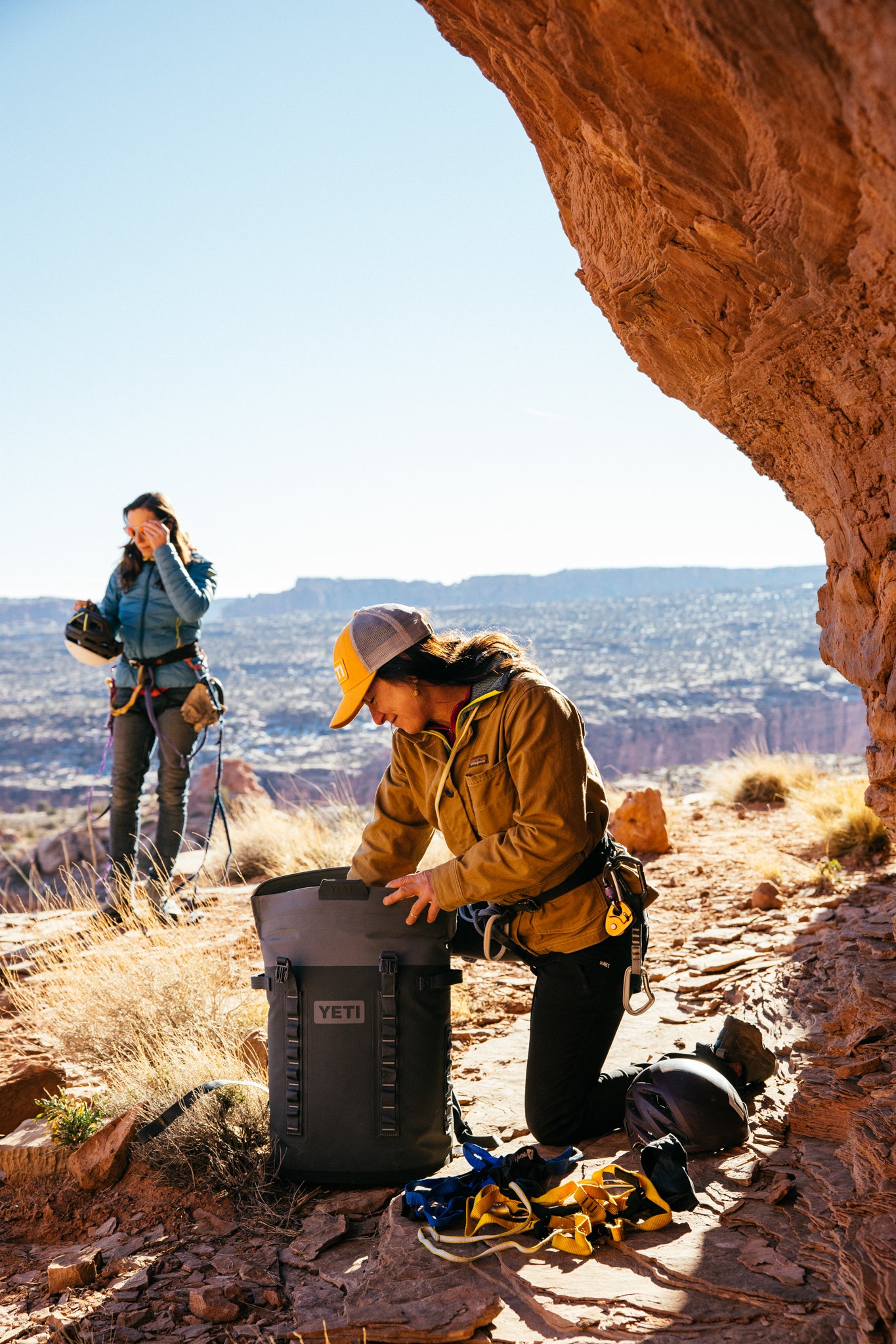 Climbers prepare with the classic, high-end Navy Hopper M20 Backpack, effortlessly organizing gear in a fun, adventurous desert setting.