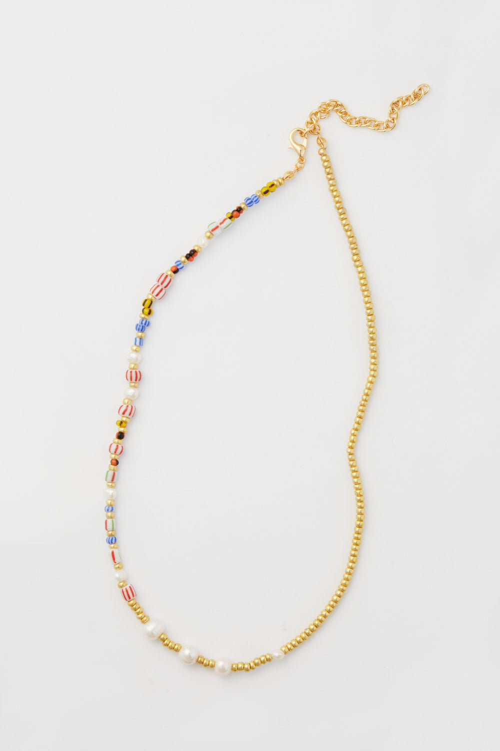 Petit Moments necklace featuring a mixed-media design with one half colorful beads, the other half small gold beads, finished with a gold chain and clasp.