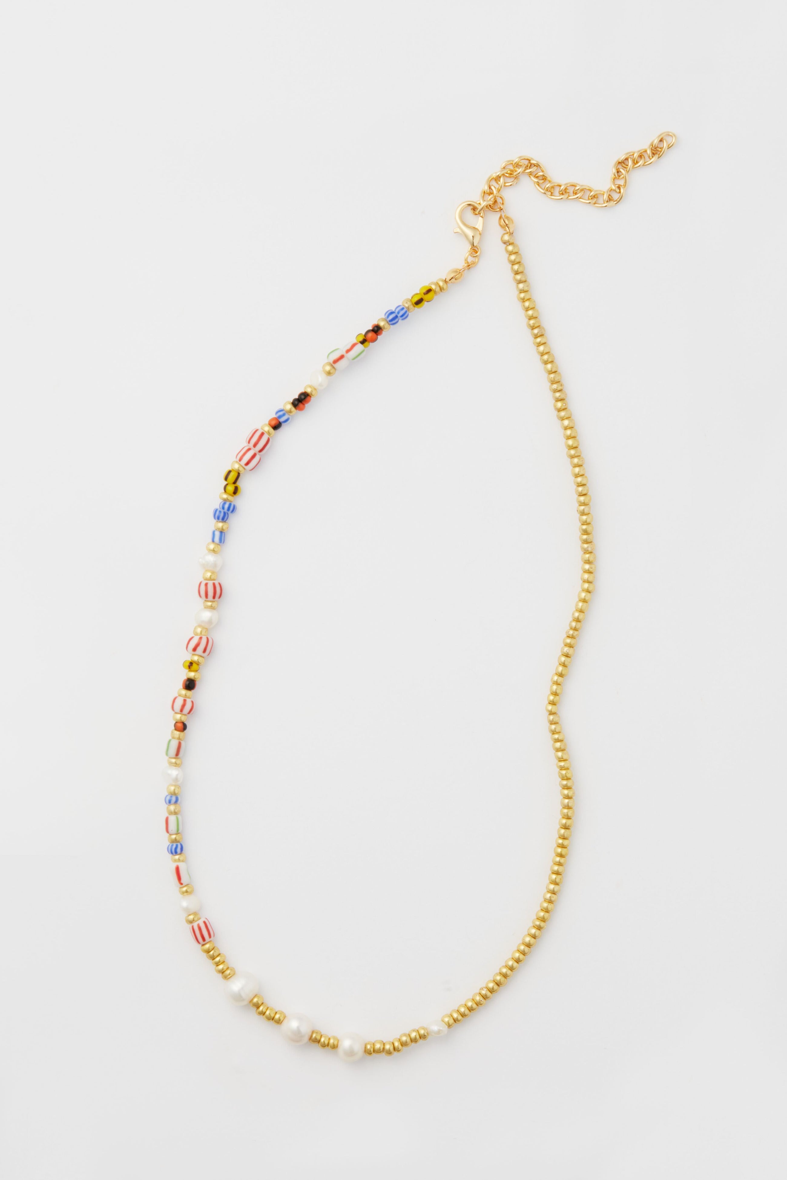 Petit Moments necklace featuring a mixed-media design with one half colorful beads, the other half small gold beads, finished with a gold chain and clasp.