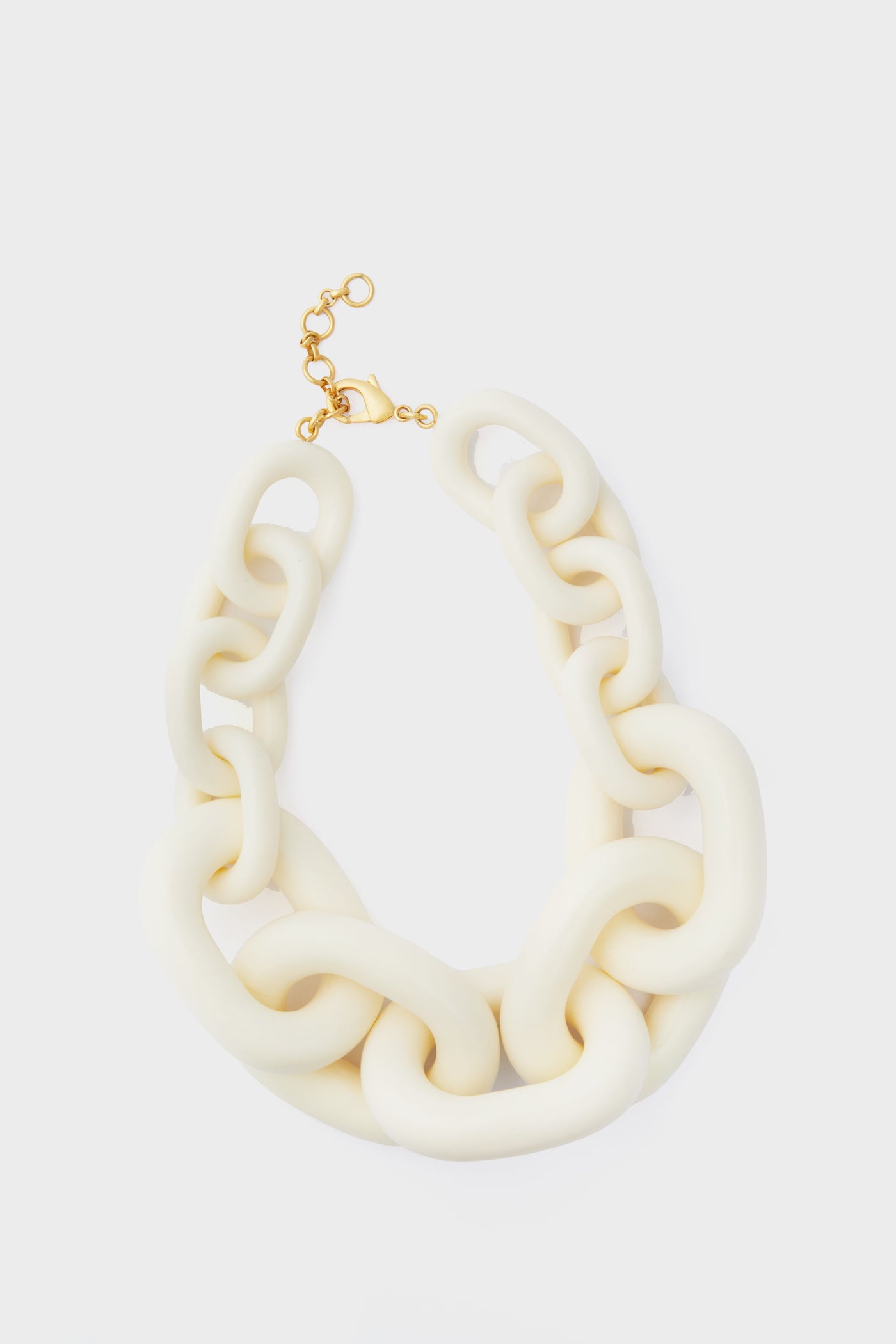 Tuckernuck Jewelry’s chunky, oversized cream-colored statement necklace features a gold clasp and adjustable links for an eye-catching accessory.