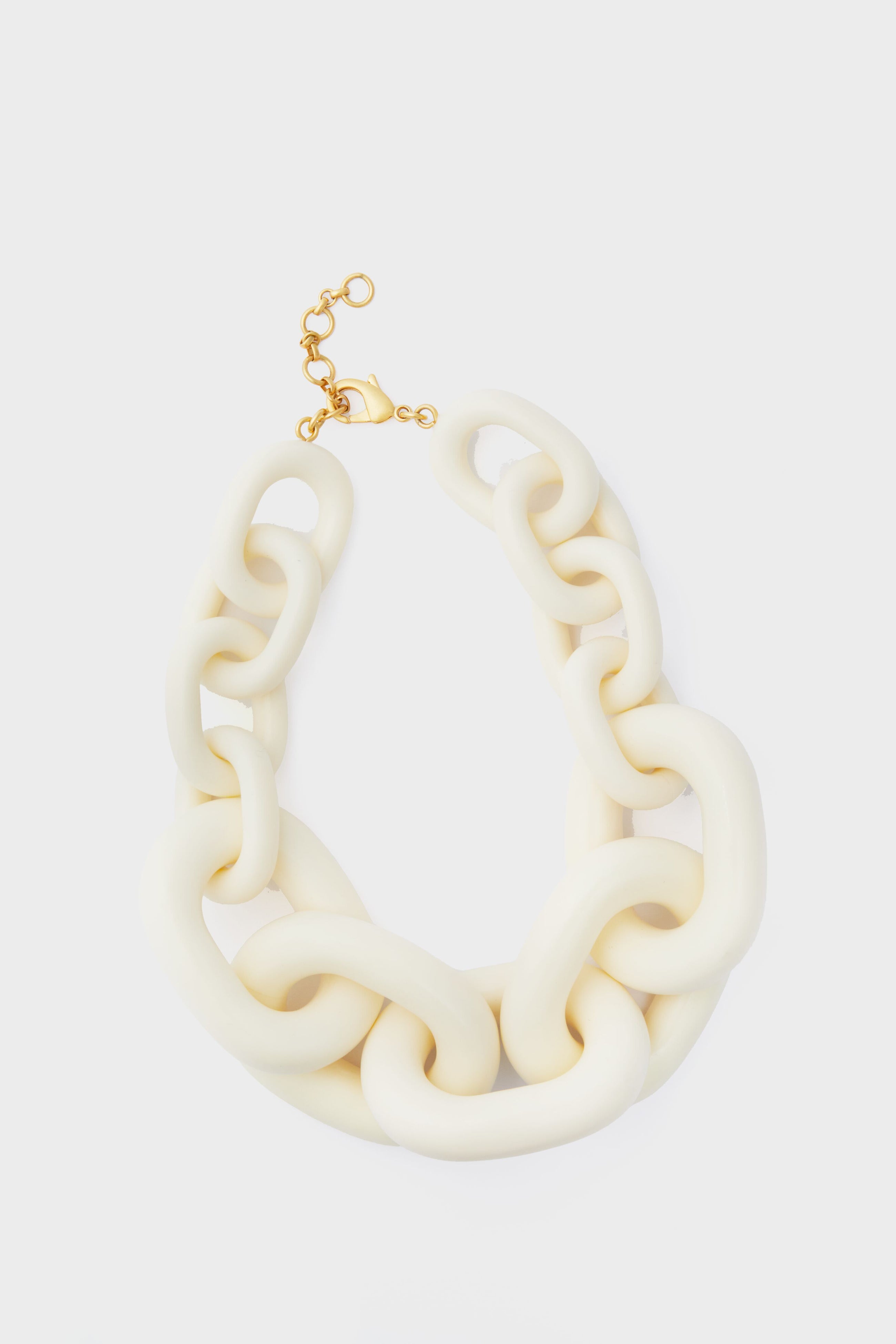 Tuckernuck Jewelry’s chunky, oversized cream-colored statement necklace features a gold clasp and adjustable links for an eye-catching accessory.