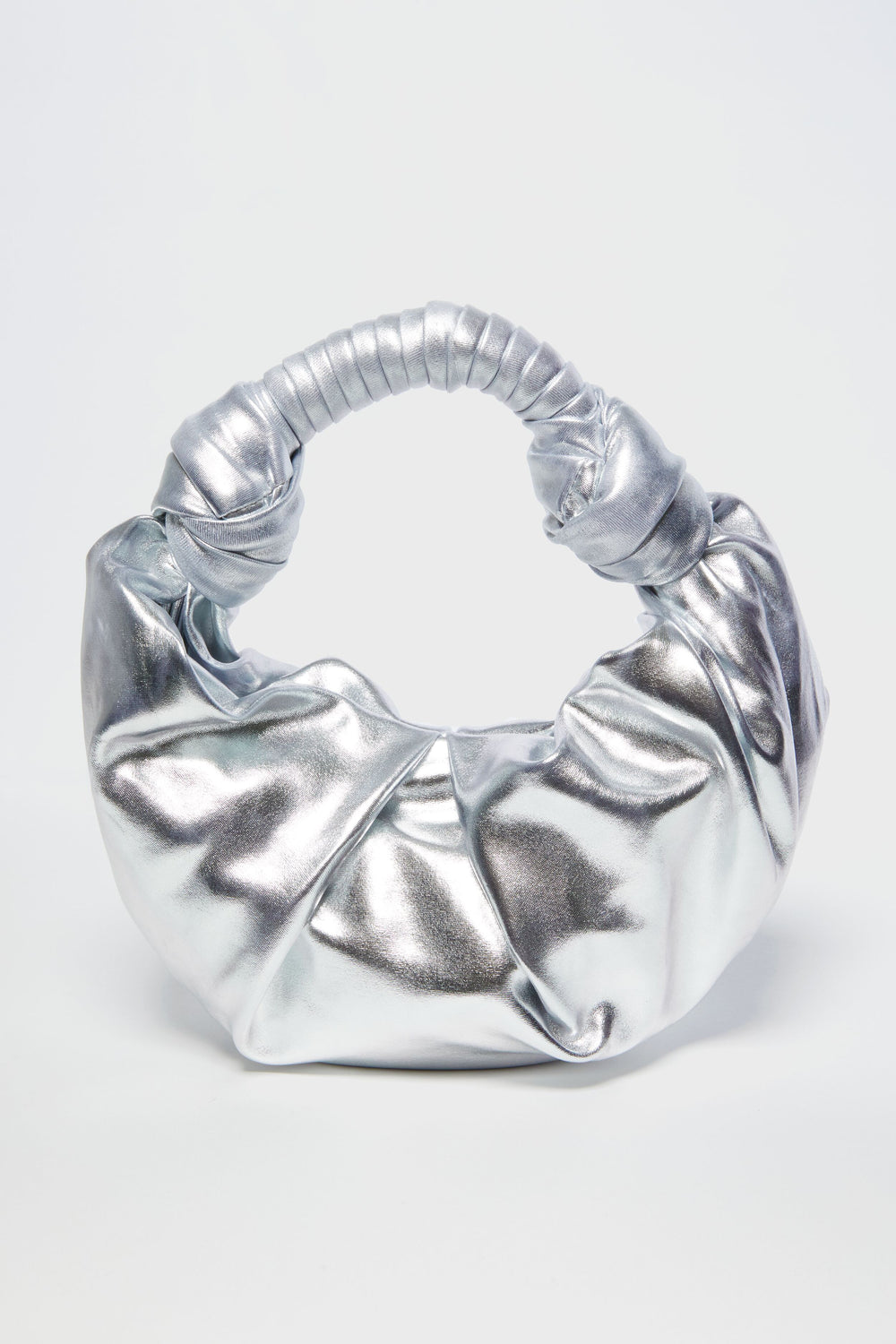 The Simon Miller Lopsy Bag is a small, silver statement purse crafted from metallic vegan leather with a scrunched, knotted handle and a shiny, crinkled texture.