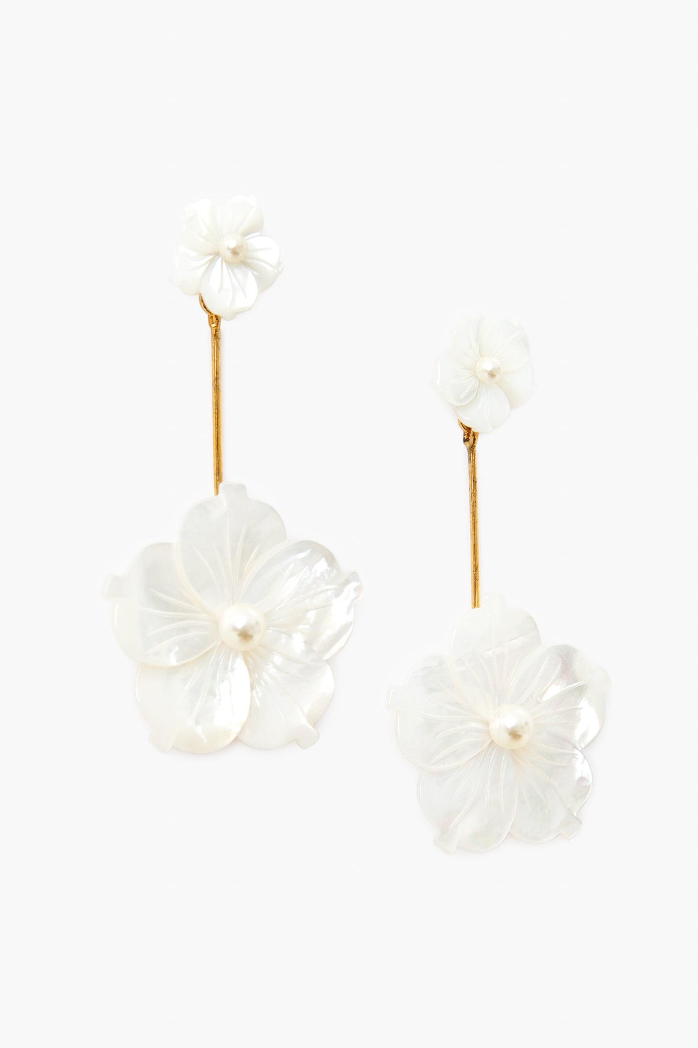 Jennifer Behr Floral Drop Earrings feature gold-colored stems and white flower-shaped designs with pearl-like centers, making them a perfect choice for handmade jewelry lovers.