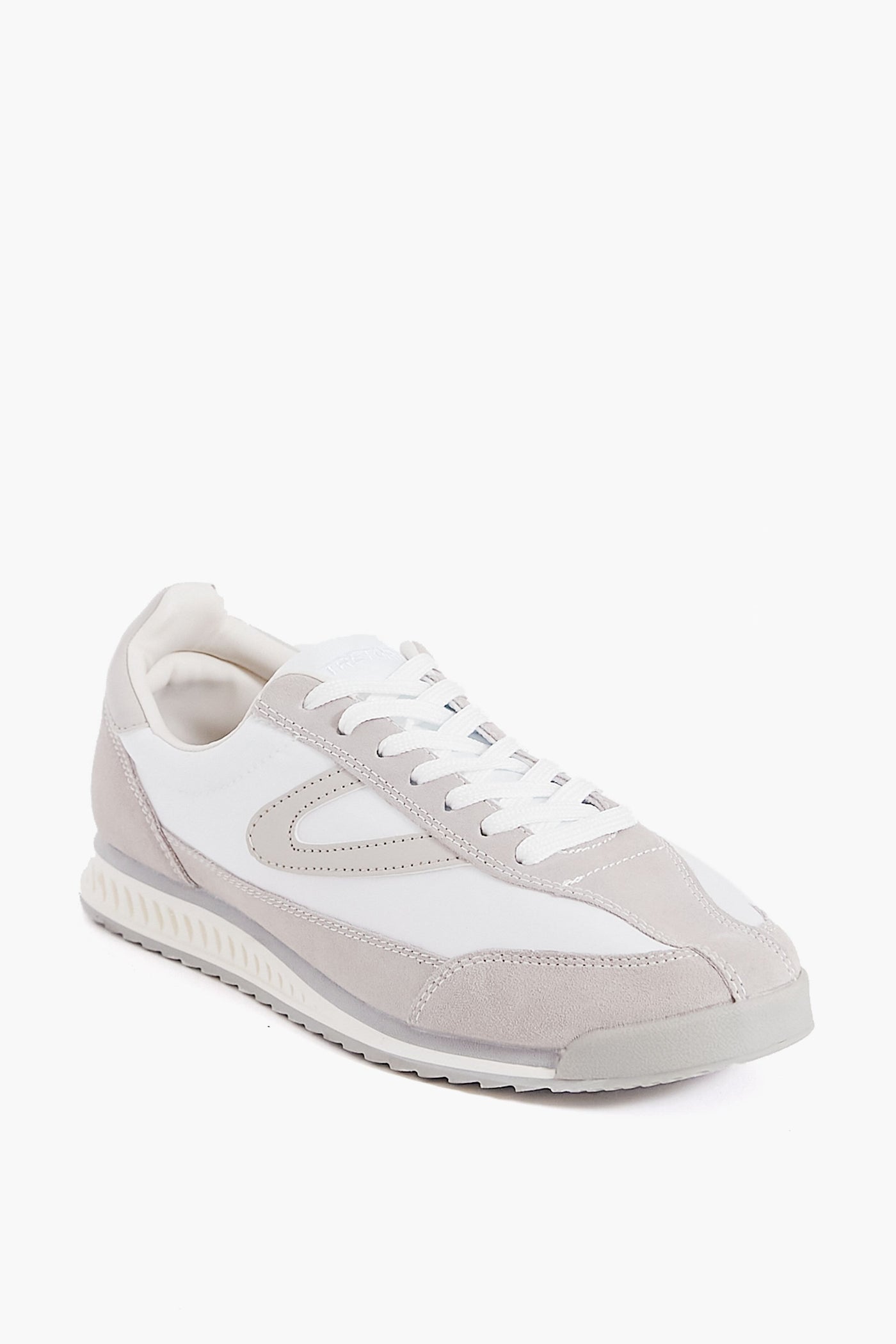 A Tretorn Rawlins 2.0 sneaker in white, featuring white laces, a textured sole, and suede and leather panel details, is pictured at a three-quarter angle.