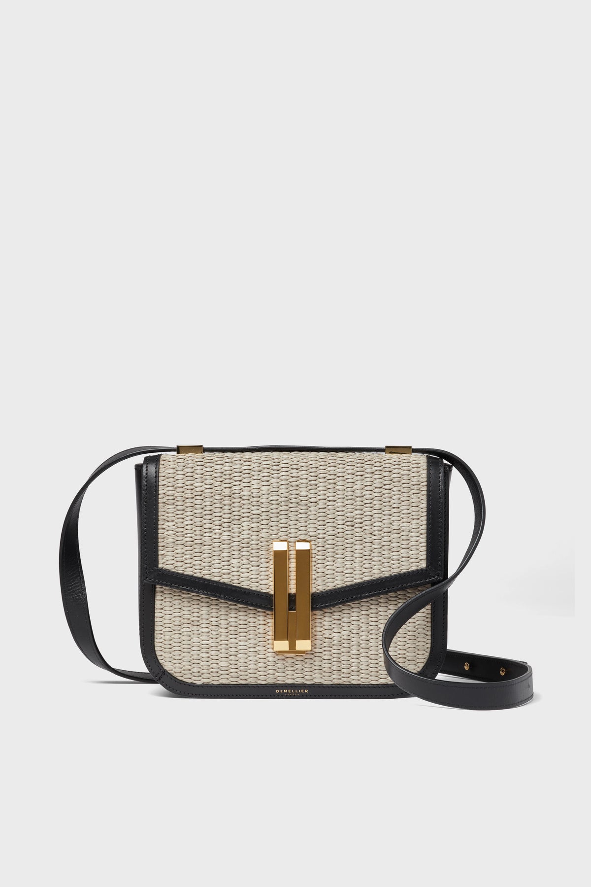 Demellier rectangular crossbody purse featuring a woven beige raffia front, black leather trim and strap, plus a gold-tone rectangular clasp—an elegant handcrafted bag blending style and versatility.