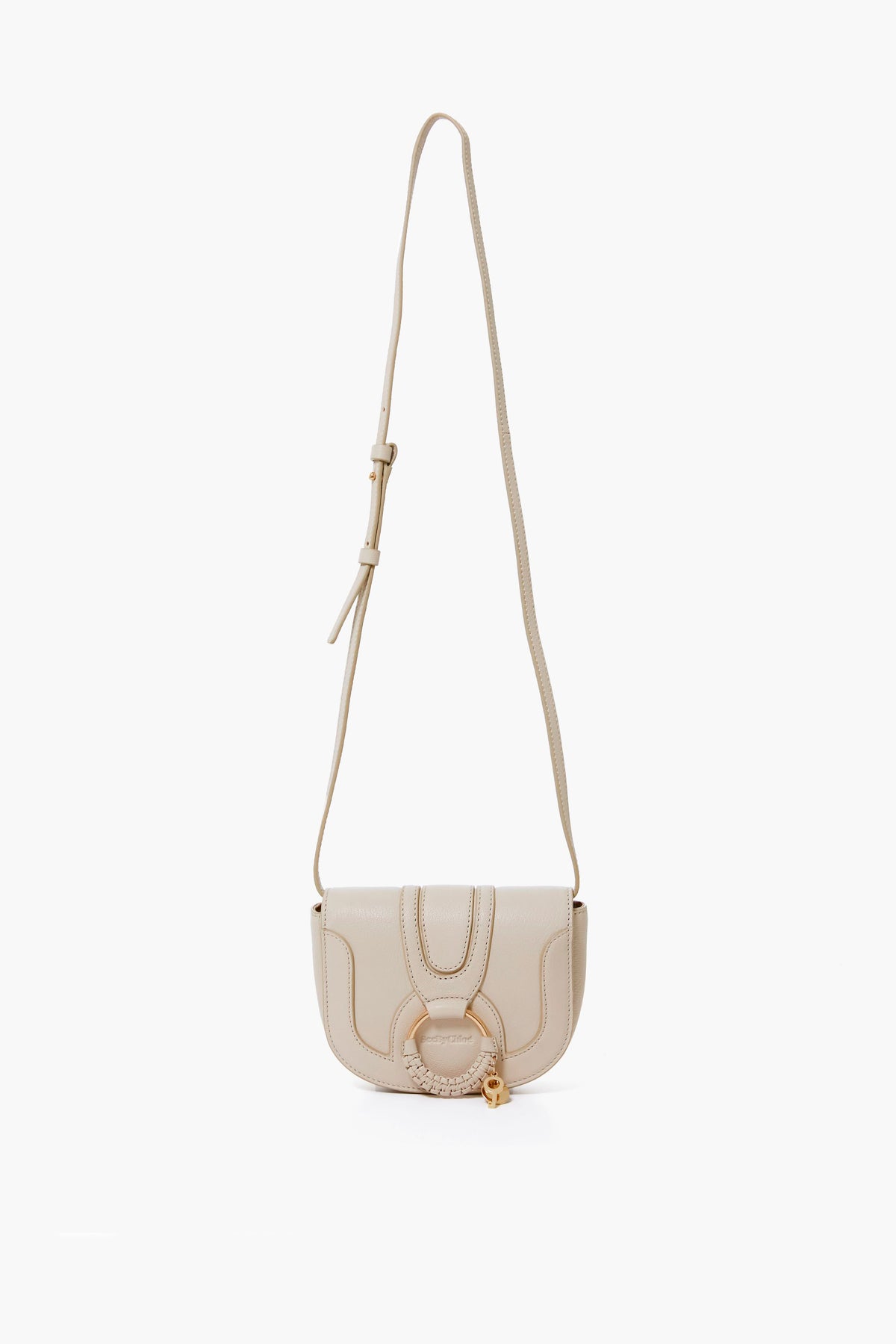A small beige See by Chloe Mini Hana Bag featuring an adjustable strap, flap closure, and signature front ring detail—a stylish goatskin designer crossbody ideal for any occasion.