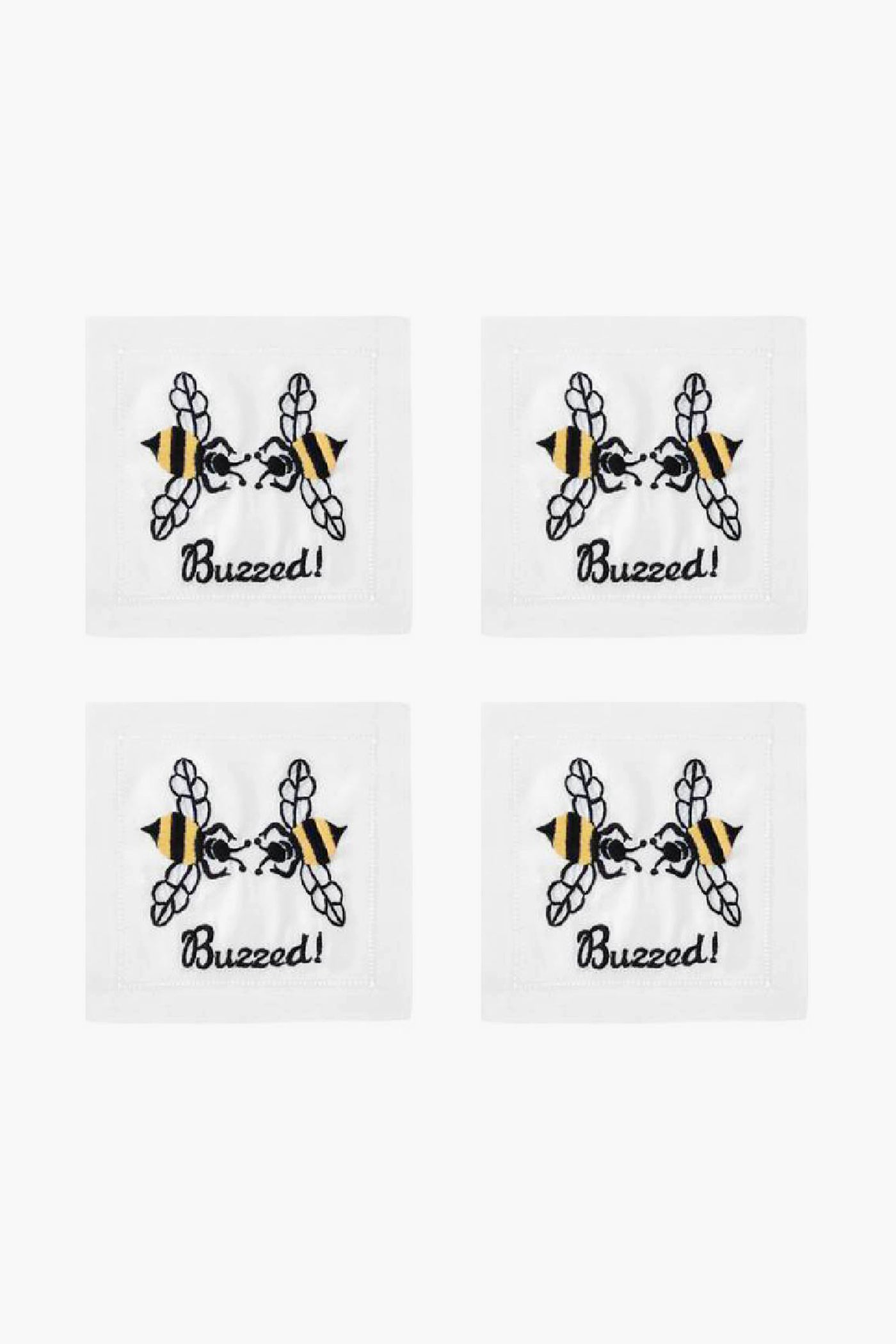 Set of four white August Morgan cocktail napkins, each with an embroidered bee above the word “Buzzed!” in black script—ideal for entertaining guests.