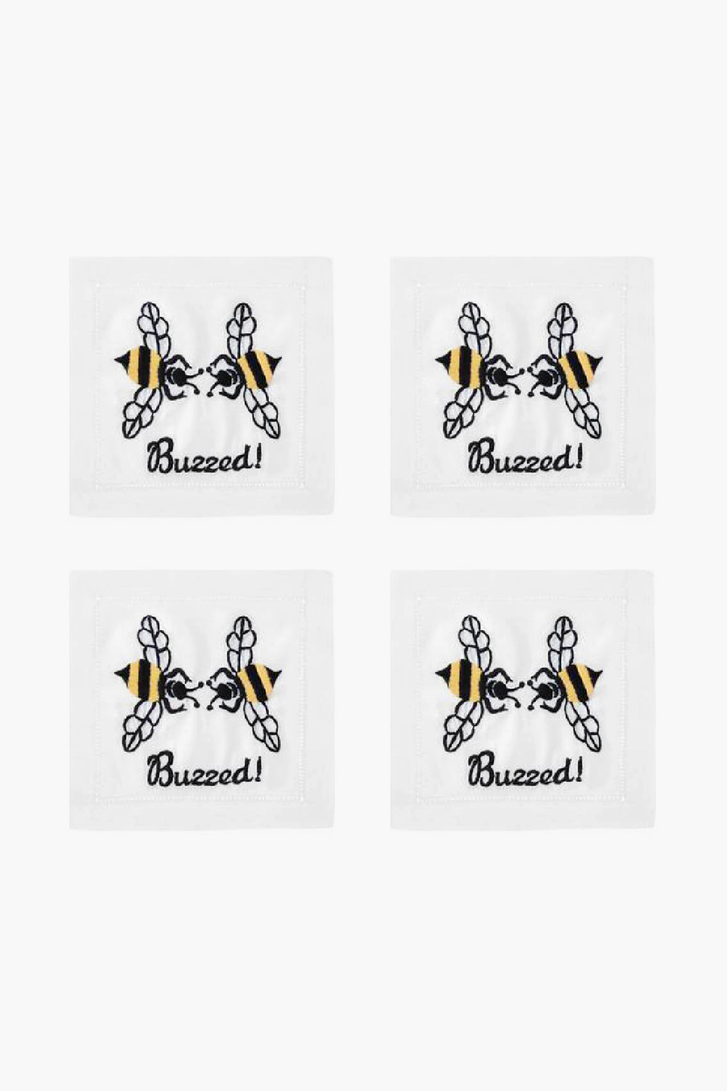 Set of four white August Morgan cocktail napkins, each with an embroidered bee above the word “Buzzed!” in black script—ideal for entertaining guests.