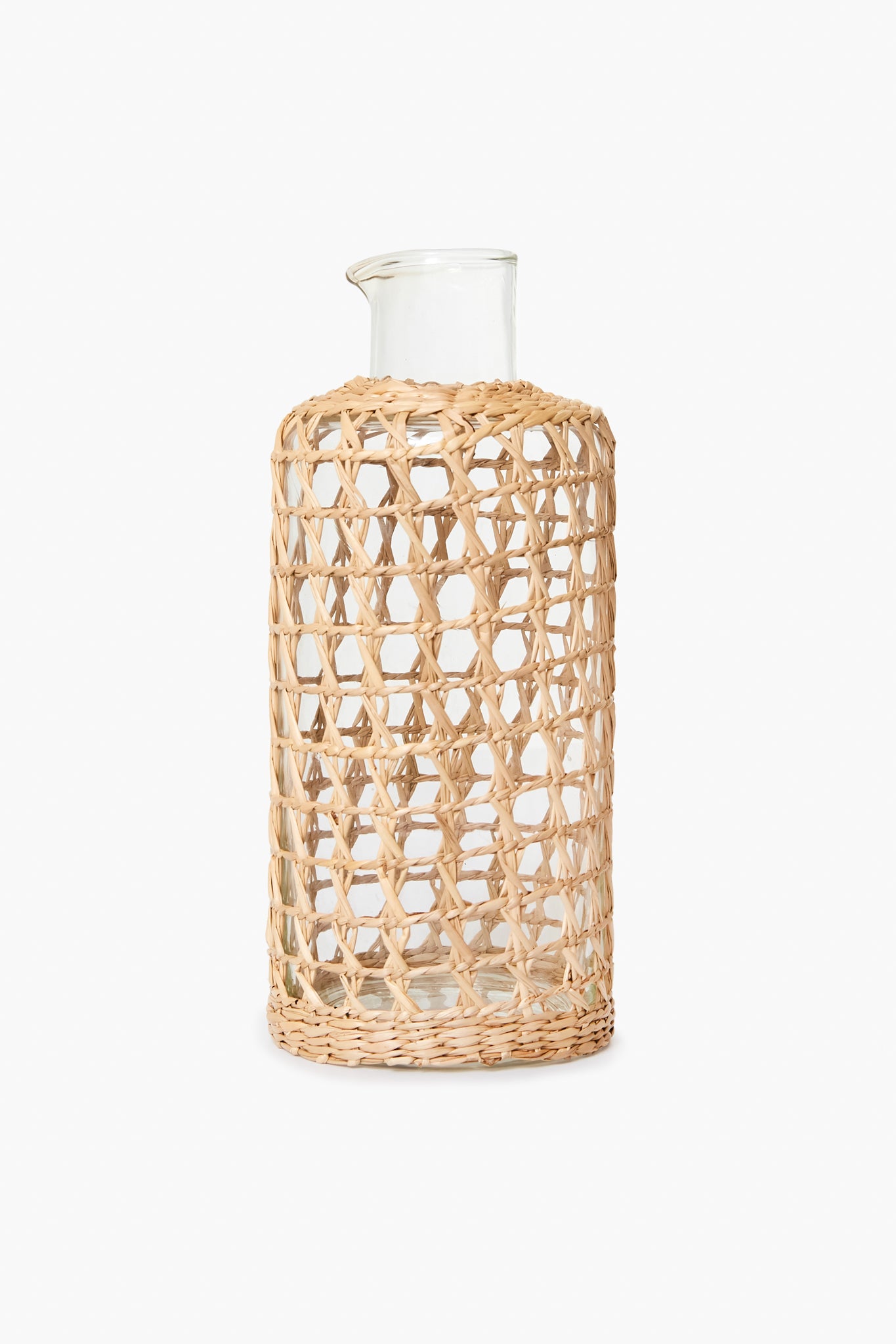 The Seagrass clear glass carafe features a woven openwork rattan sleeve covering most of its body, making it perfect for coastal home decor.
