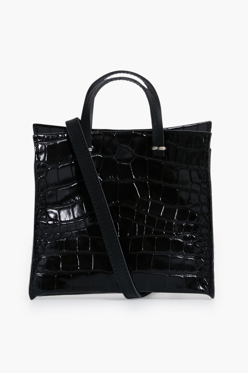 A Clare V black leather crossbody bag featuring a croc-embossed texture, two short handles, and a long shoulder strap draped across the front.
