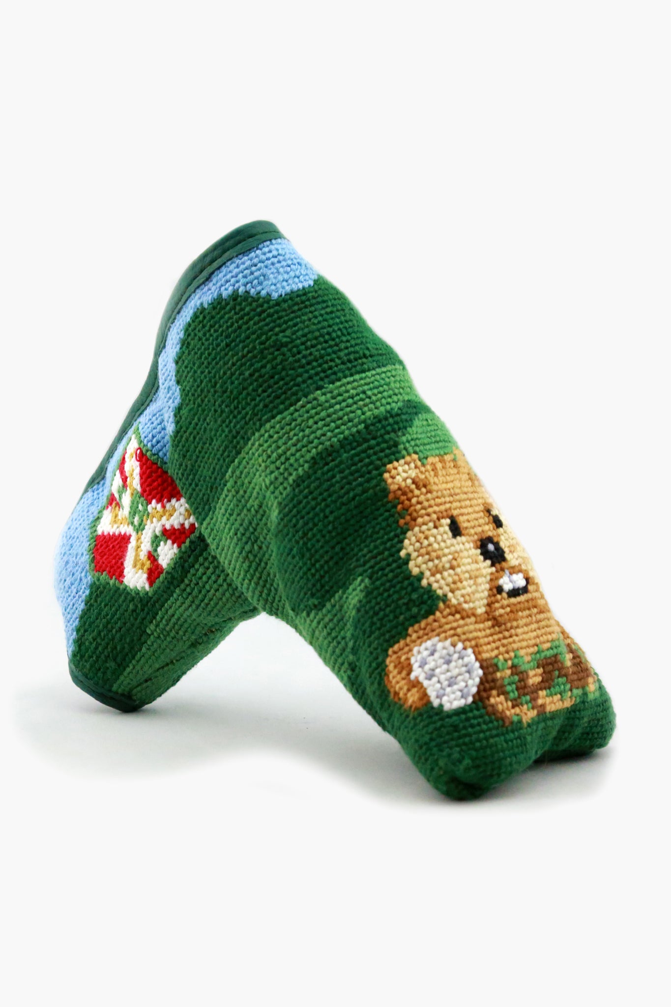 A pair of green Smathers and Branson slippers with hand-stitched needlepoint: a bear holding an acorn, a red-and-white mushroom, and a gopher-inspired motif.