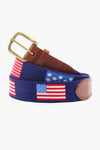 A blue Smathers and Branson needlepoint belt with hand-stitched American flags, brown leather accents, and a brass buckle.