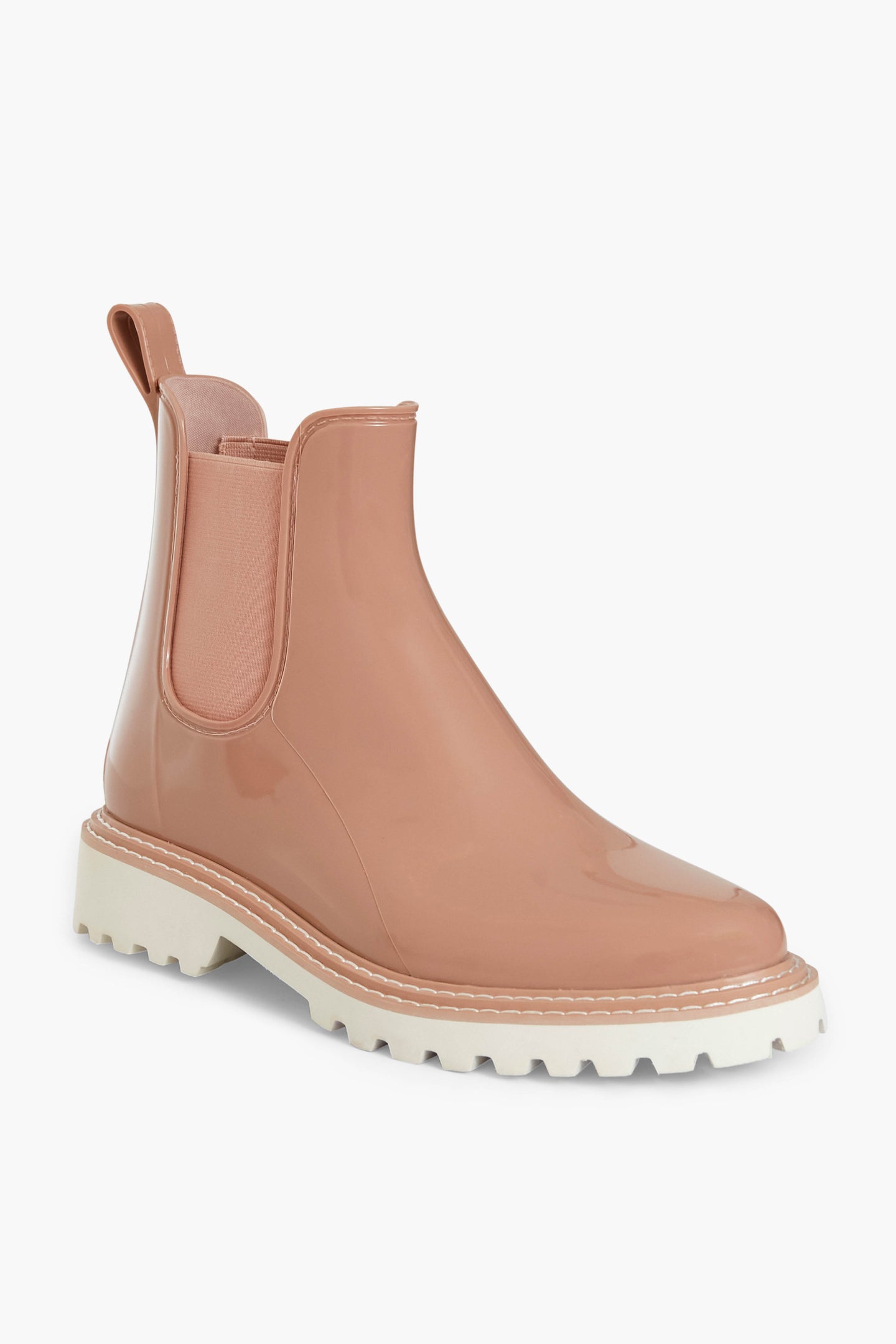A single Dolce Vita pink Chelsea boot with a glossy, water-repellent finish, pull tab, elastic side panel, and chunky white sole.