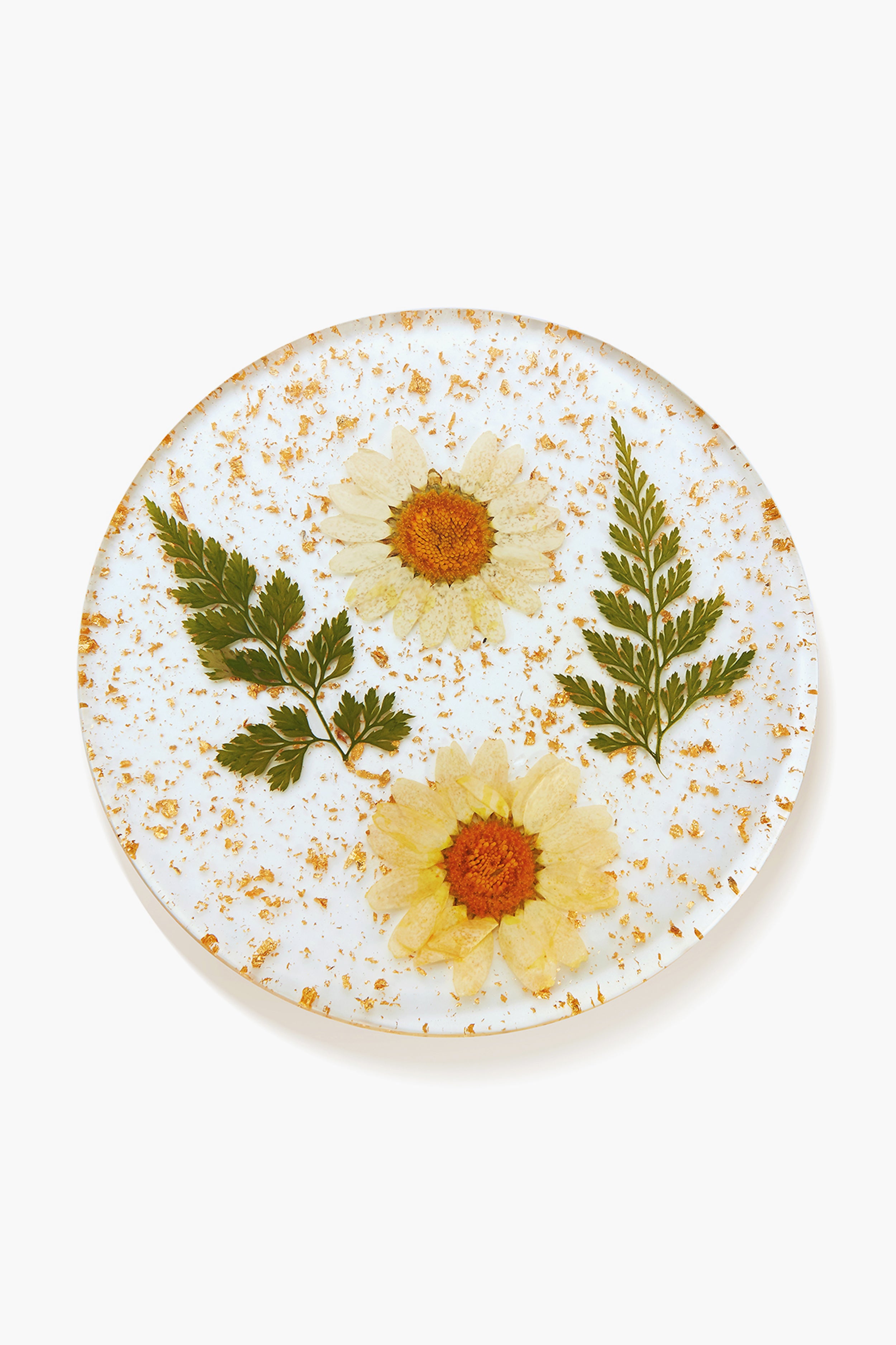 Chefanie round glass plate featuring two pressed white daisies, two fern leaves, and gold flecks—ideal as coffee table decor or a unique housewarming gift.
