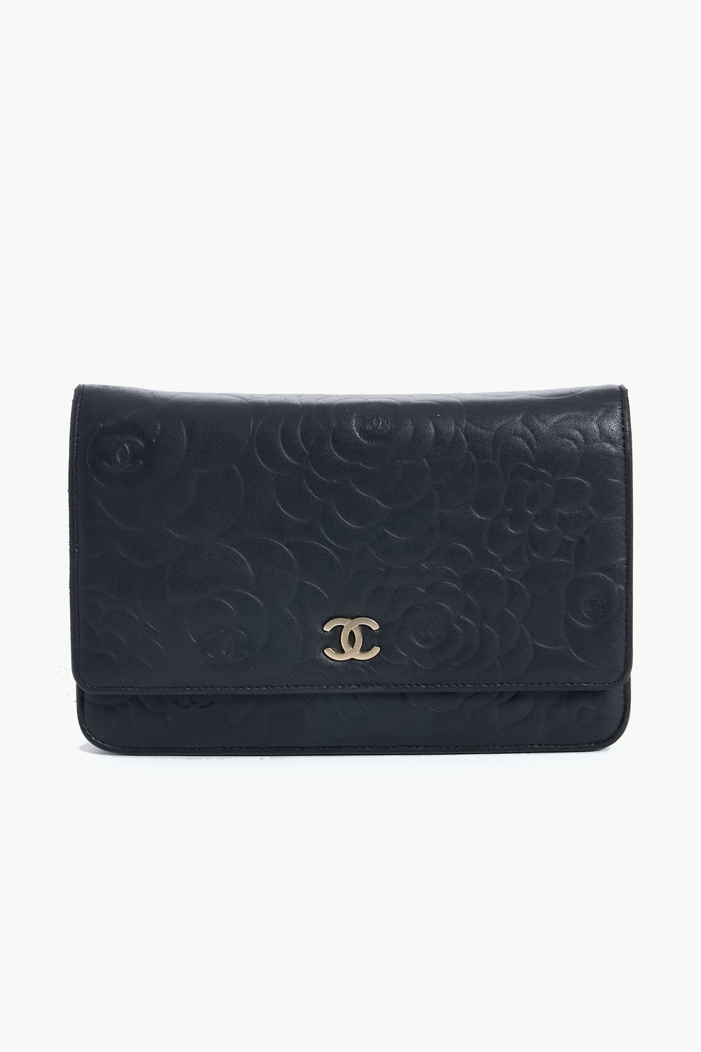 A black leather clutch from Tuckernuck Archive Collection featuring an embossed floral pattern and a gold logo on the front flap.
