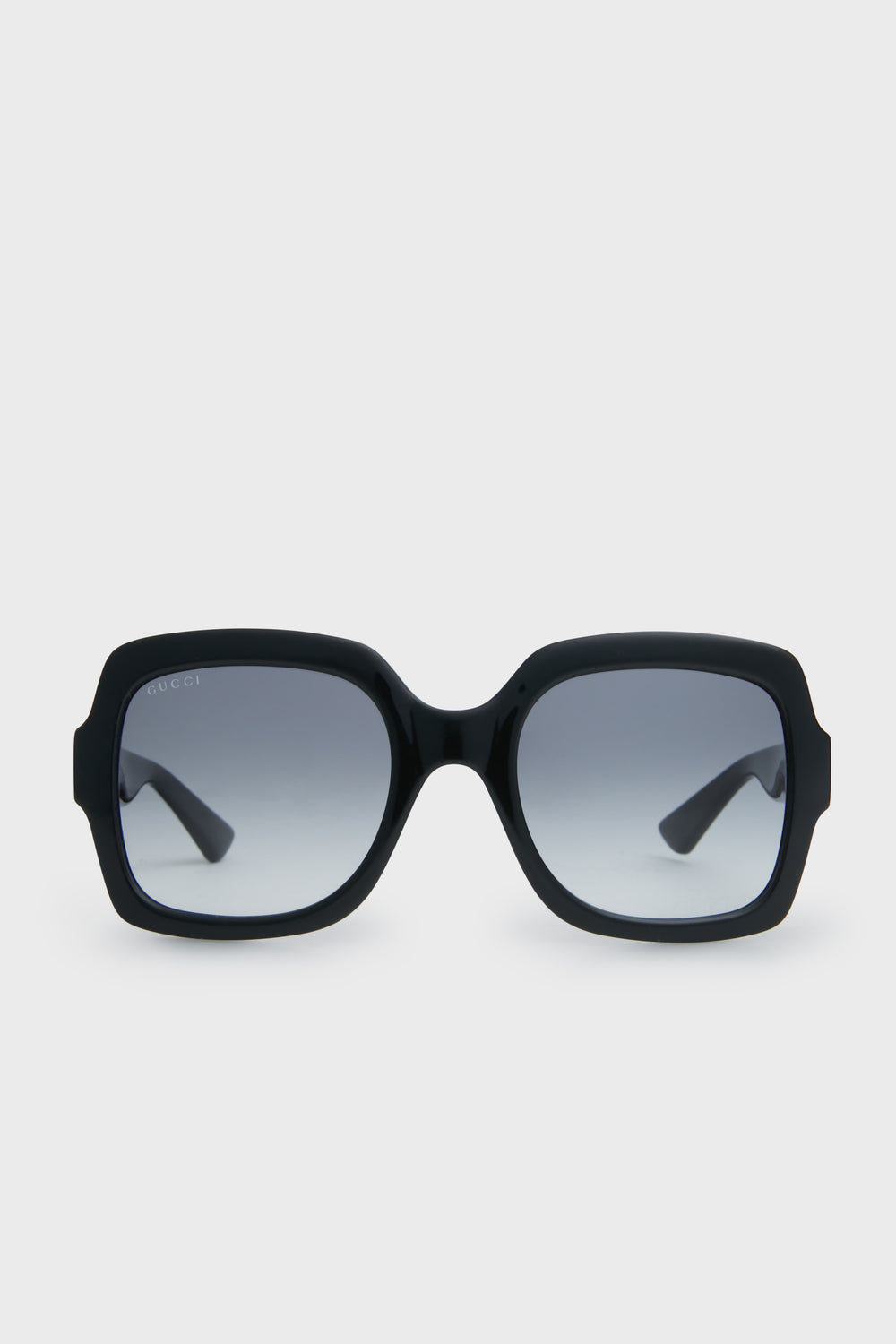 Gucci black square sunglasses with thick frames and gradient lenses embody luxury fashion.