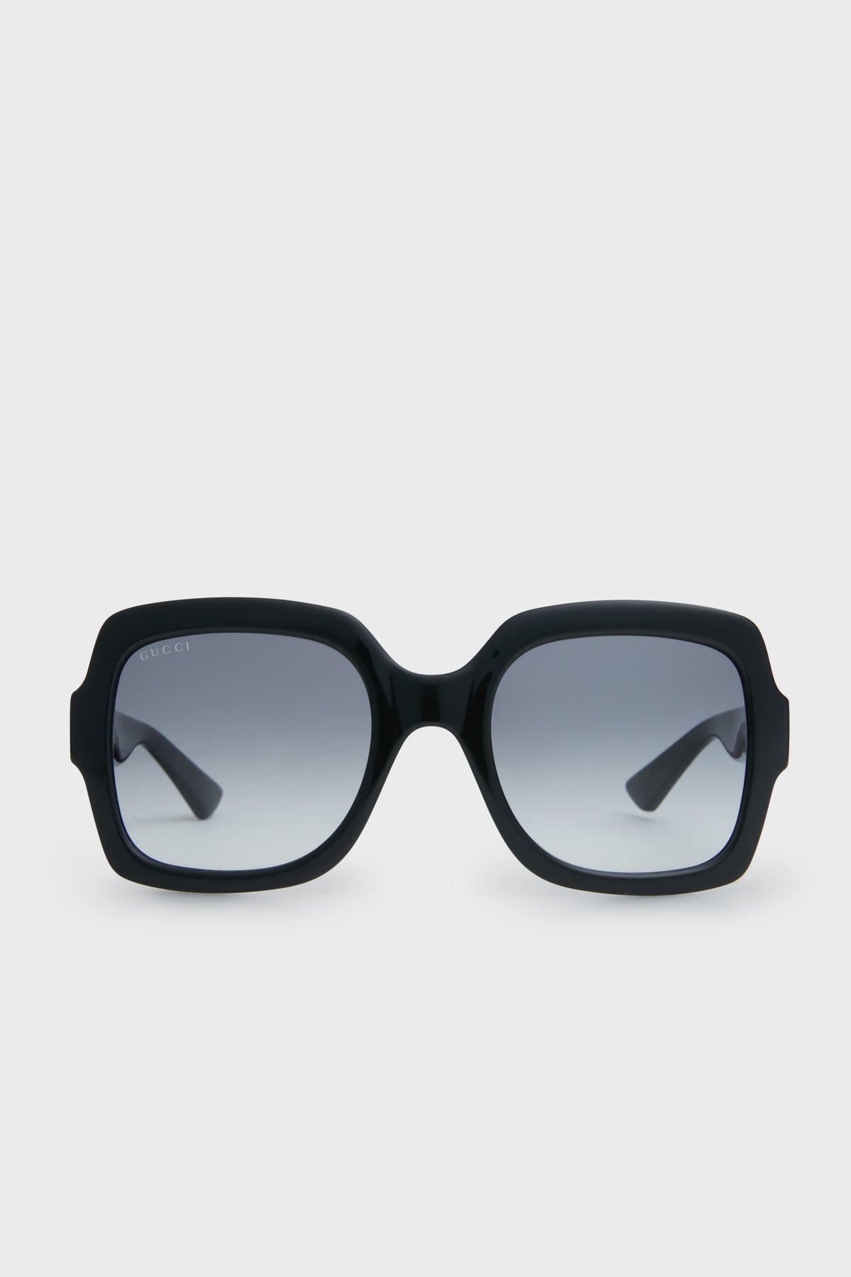 Gucci black square sunglasses with thick frames and gradient lenses embody luxury fashion.
