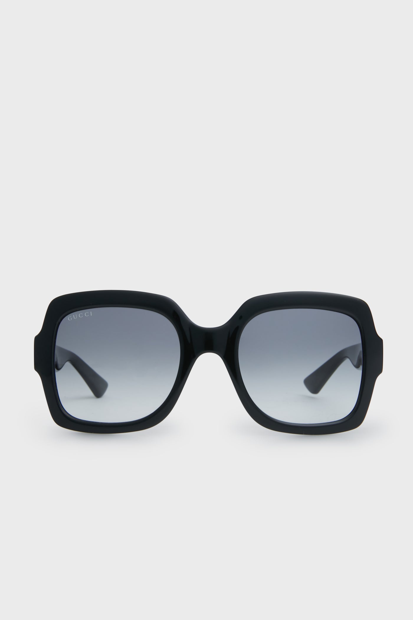 Gucci black square sunglasses with thick frames and gradient lenses embody luxury fashion.
