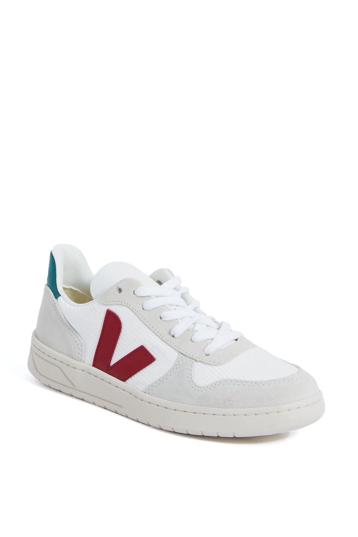 The VEJA low-top sneaker features a white design with light gray suede accents, a red V logo on the side, and a teal heel patch, all crafted from eco-friendly materials.