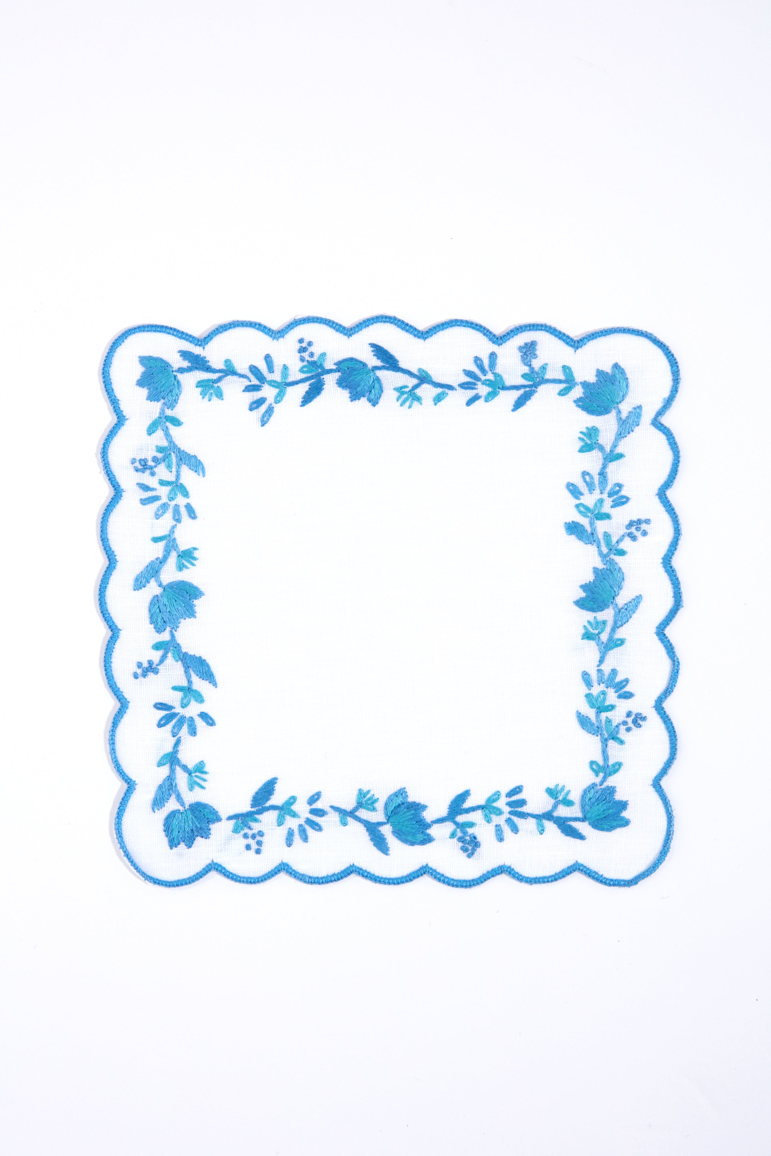 Tuckernuck Home’s square white handkerchief features blue scalloped edges and floral embroidery, making it perfect as a Blue and White Floral Cocktail Napkin for decorating your next cocktail party.