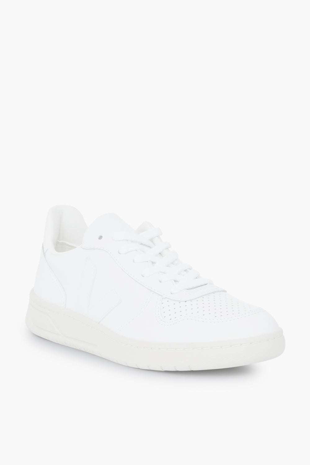 A white low-top VEJA sneaker featuring perforated toe details, white laces, and a white rubber sole—combining sustainable design with classic style.