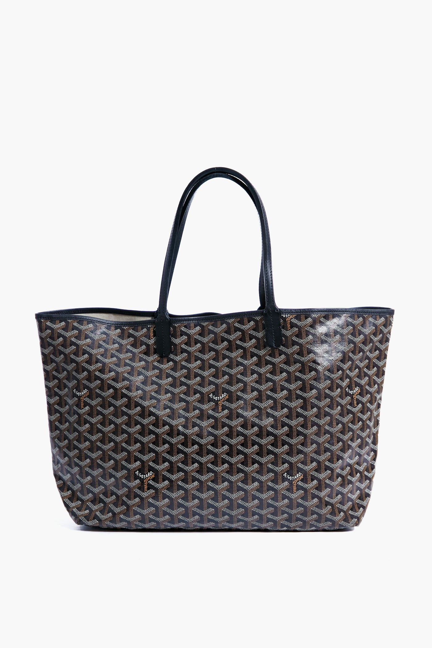 A black and brown patterned tote from the Tuckernuck Archive Collection featuring two long black handles.