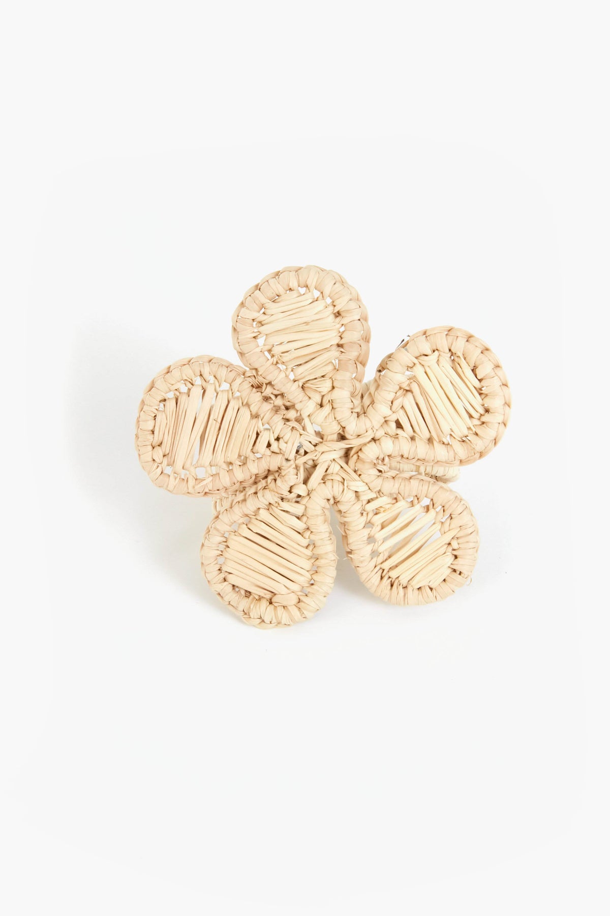 A woven straw napkin ring by Coro Cora, shaped as a five-petal flower and handmade from Iraca palm, offers unique Colombian artisan homeware style.