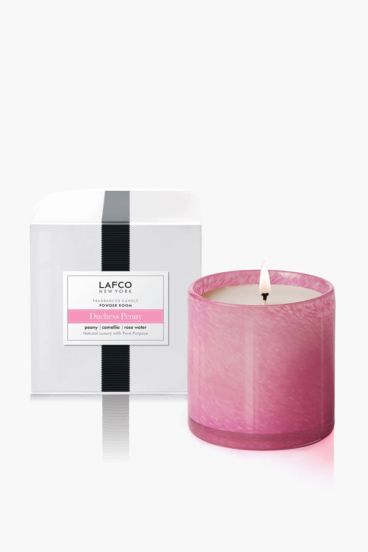 A LAFCO New York hand-blown glass Duchess Peony candle glows beside its elegant white box with black accents—a stylish, fragrant addition to your home décor.