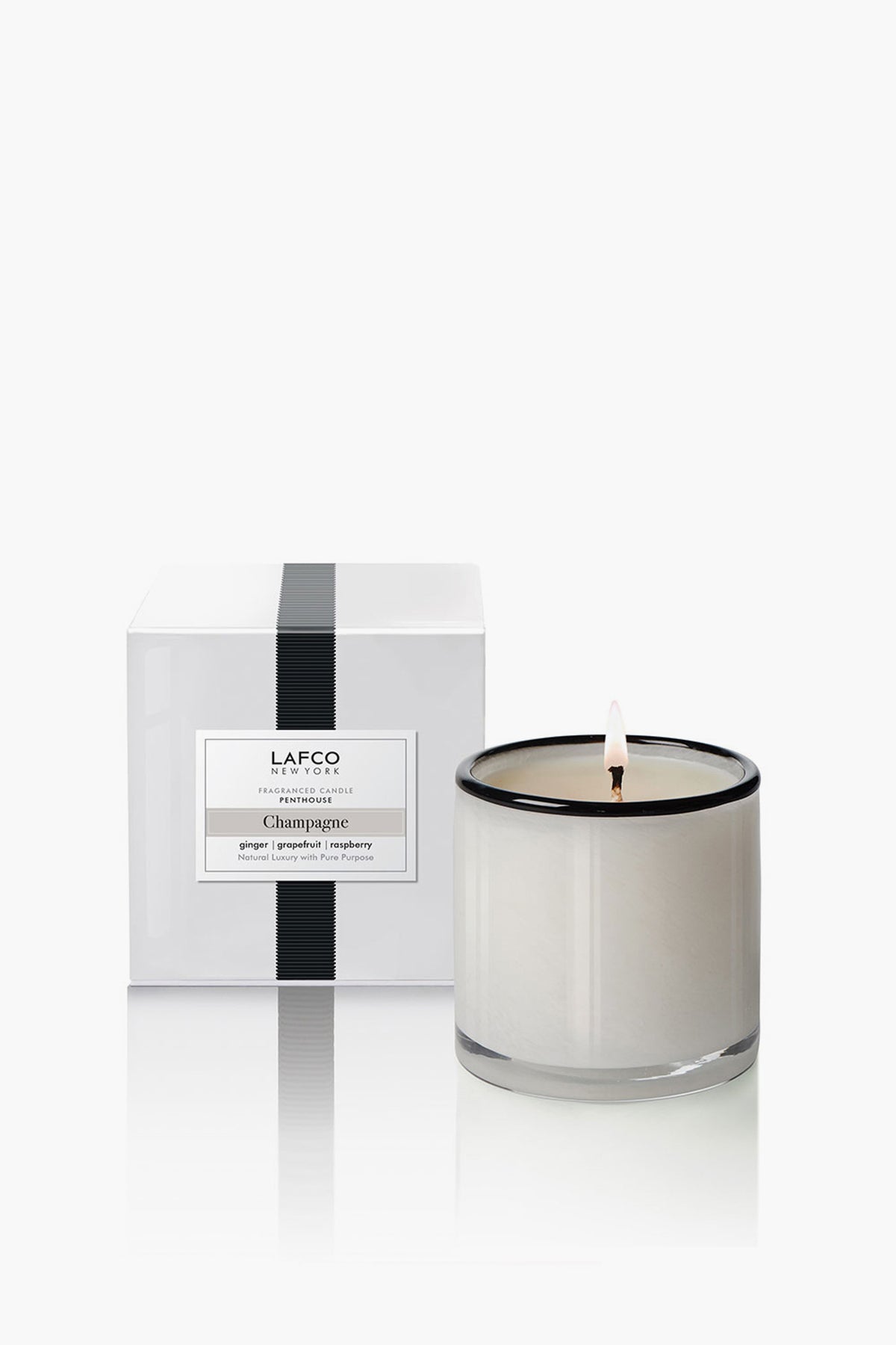Champagne Signature Candle in a classic glass vessel with matching boxed packaging. Offers an effortless, high-end fragrance experience with notes of grapefruit, ginger, and raspberry.