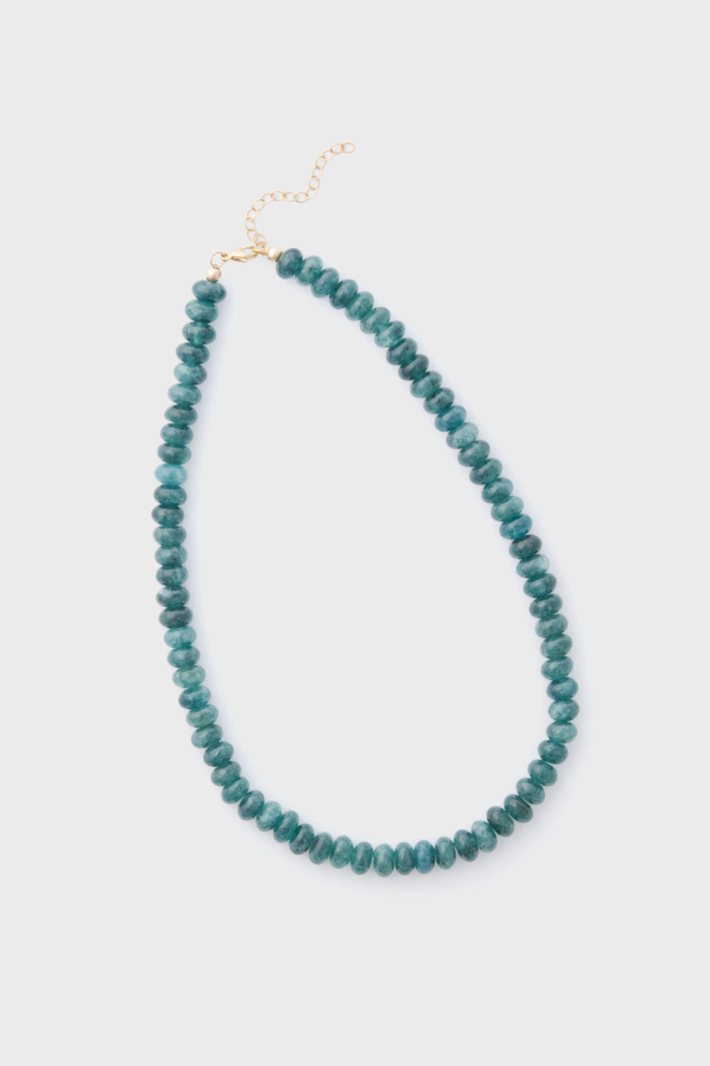 The Alexa Leigh Turquoise Opal Necklace features round teal beads, a gold clasp, and an adjustable length chain, all arranged in a loop.
