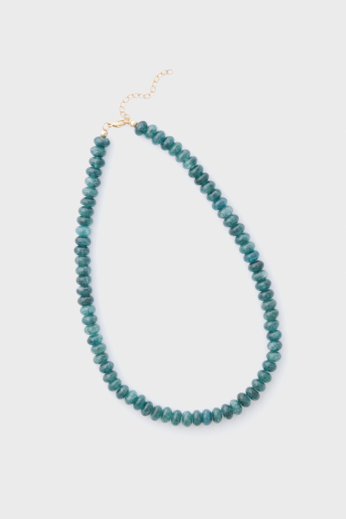 The Alexa Leigh Turquoise Opal Necklace features round teal beads, a gold clasp, and an adjustable length chain, all arranged in a loop.