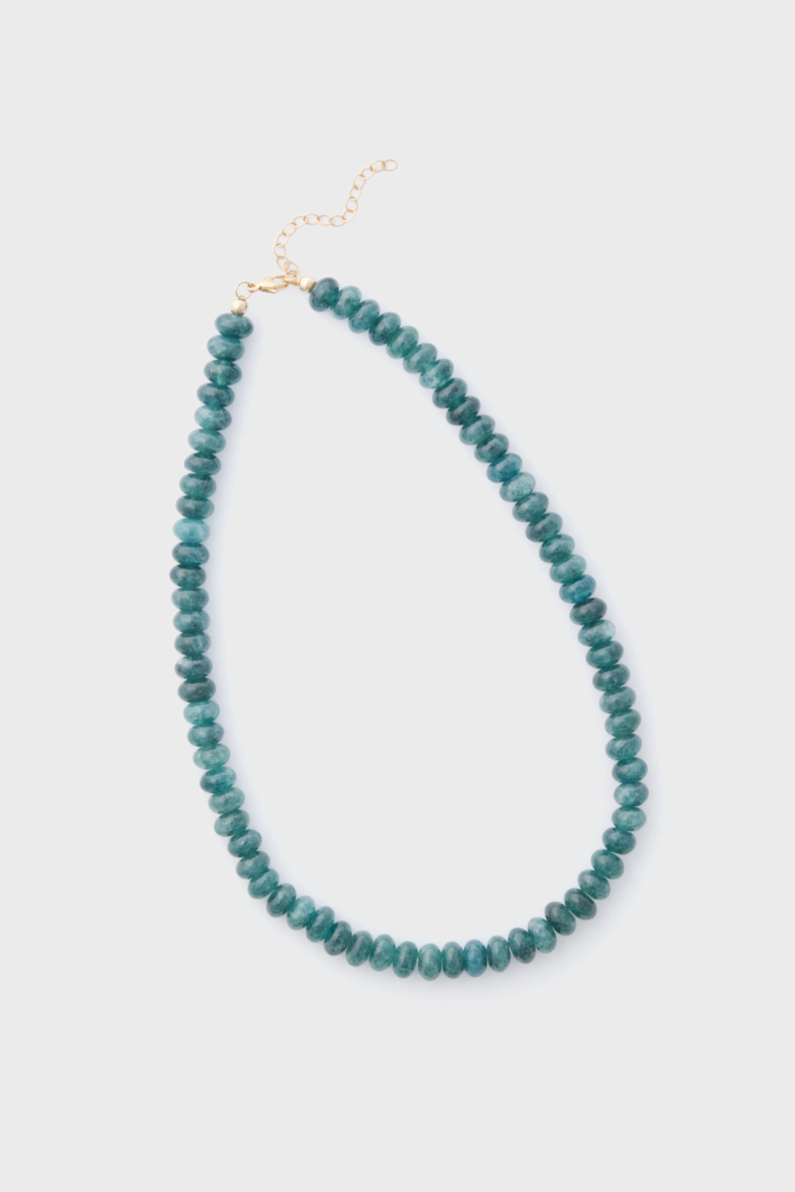 The Alexa Leigh Turquoise Opal Necklace features round teal beads, a gold clasp, and an adjustable length chain, all arranged in a loop.