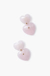 Tuckernuck Jewelry offers gold-plated heart earrings with pink heart-shaped stones and small gold studs, elegantly designed with layered hearts.