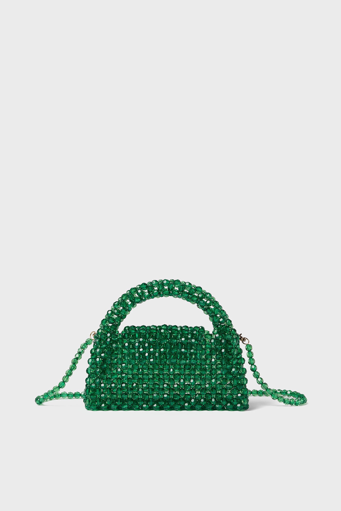 The Moda Luxe Green Dolly Bag is a small, rectangular bag crafted from green beads with a matching beaded handle and shoulder strap, offering retro glamor.