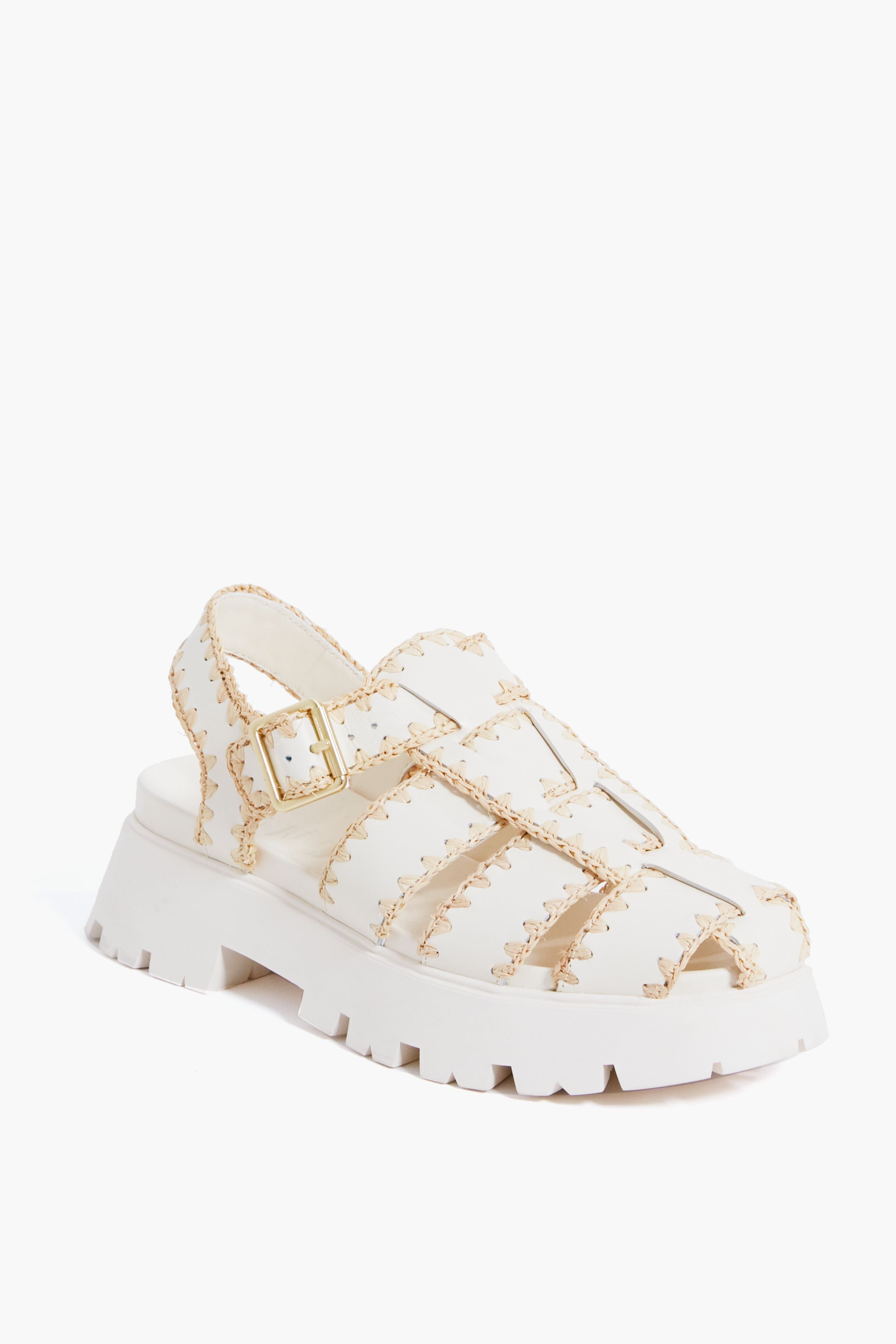A cream leather caged platform sandal by Loeffler Randall featuring a thick sole, open toe, stitched detailing, and an adjustable buckle strap.