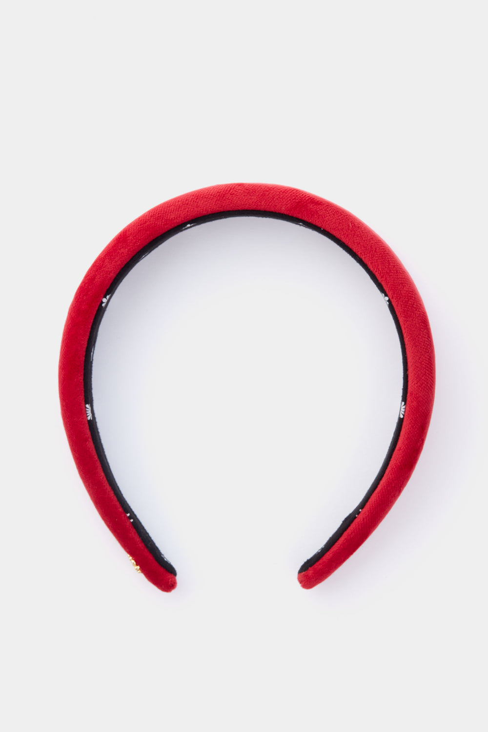 A red velvet padded knotted headband by Lele Sadoughi, featuring a black inner lining.