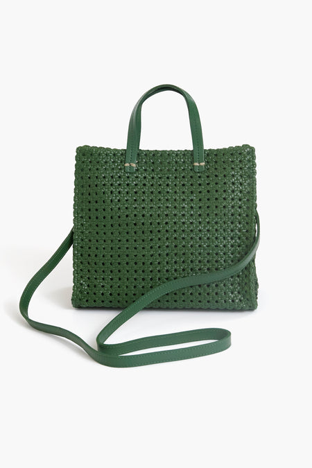 A green hand-woven leather bag by Clare V, featuring Parisian-inspired style, two short handles, and a long shoulder strap.