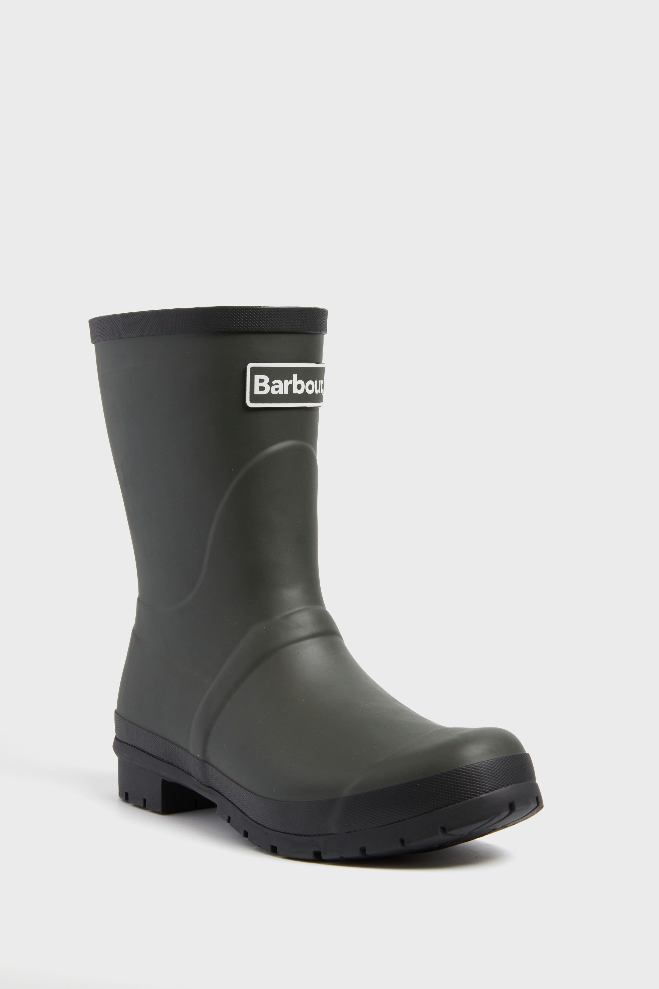 A single black Barbour wellington boot with a chunky sole and the Barbour logo on the front, ideal as waterproof outdoor footwear.